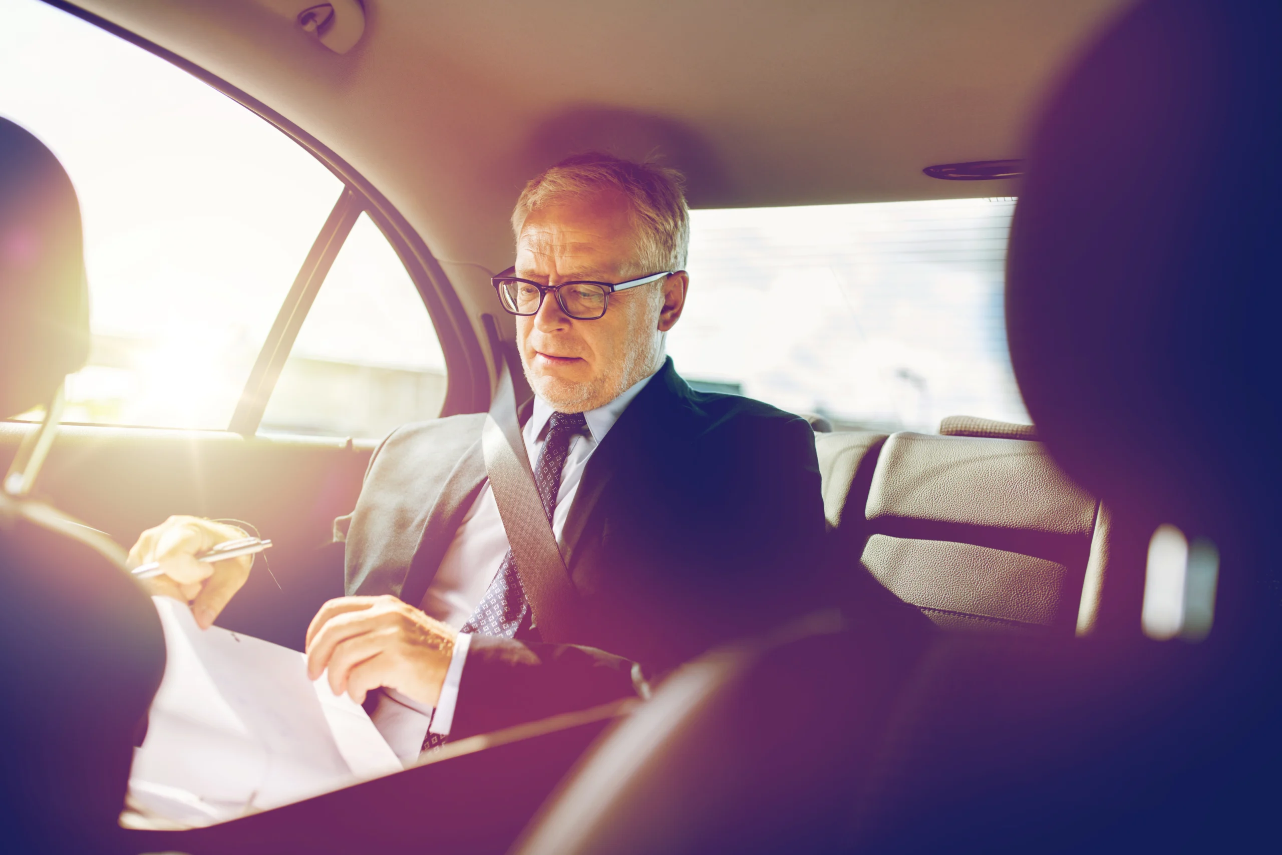 80278470_l senior businessman with papers driving in car